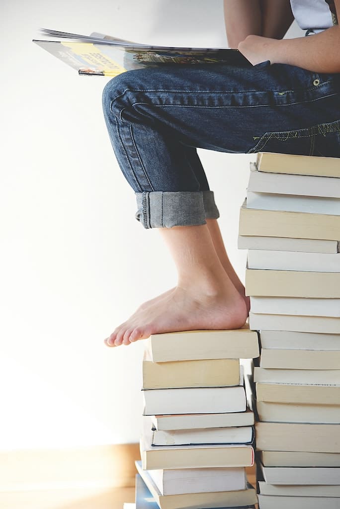 Sitzen auf Bücherstapel
